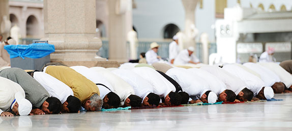 Rows of Muslim men kneeling in prayer in a mosque dedicated to Islam, the false religion based on violence and lies.