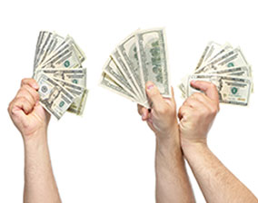 Four hands who have earned extra money hold up cash.