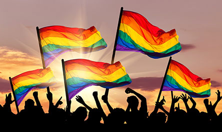 A group of people holding up rainbow flags supporting the gay agenda and gay marriage against God's wishes.